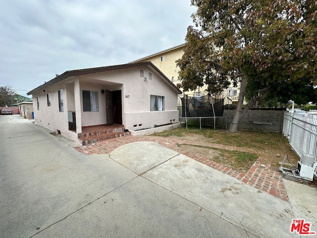 back of house with a trampoline and a patio