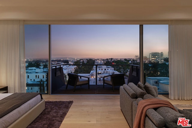 bedroom featuring expansive windows and light hardwood / wood-style flooring