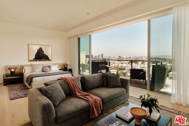 bedroom with access to exterior and hardwood / wood-style floors