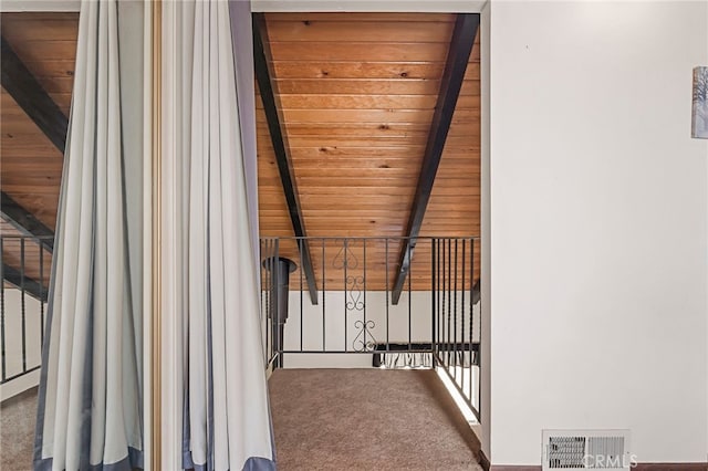 interior space featuring beam ceiling, wooden ceiling, and carpet