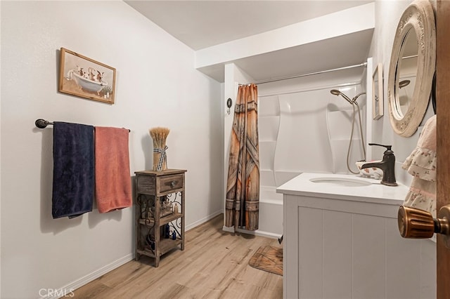 bathroom featuring hardwood / wood-style flooring, vanity, and shower / bath combo