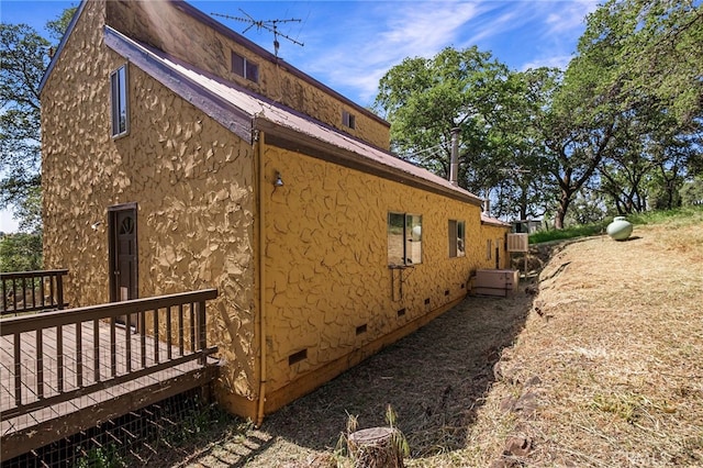 view of side of property featuring a wooden deck
