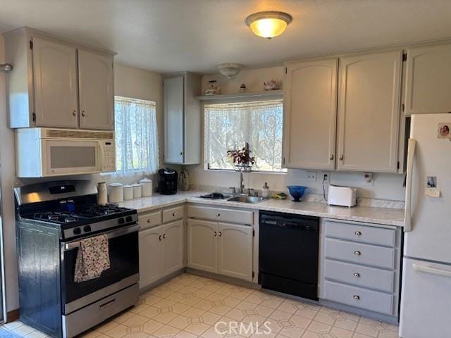kitchen with a healthy amount of sunlight, sink, and white appliances
