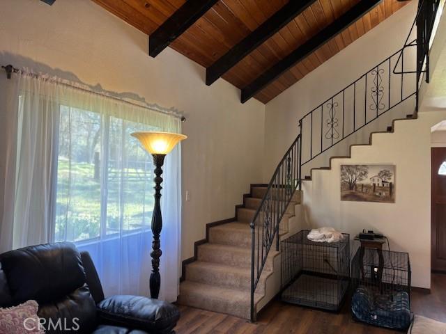 staircase with vaulted ceiling with beams, wood ceiling, and wood-type flooring