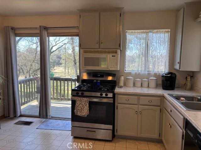 kitchen with white cabinetry, black dishwasher, sink, and stainless steel gas range oven