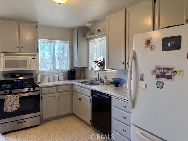 kitchen with sink, white appliances, and light tile patterned floors