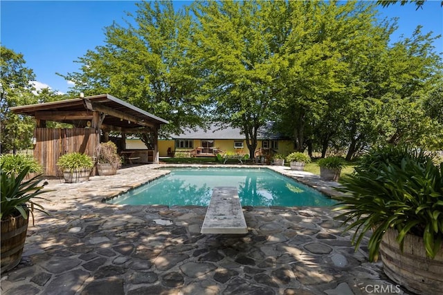 view of swimming pool with a gazebo, a patio, and a diving board