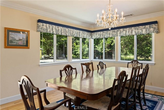 dining area featuring light hardwood / wood-style flooring, a wealth of natural light, and ornamental molding