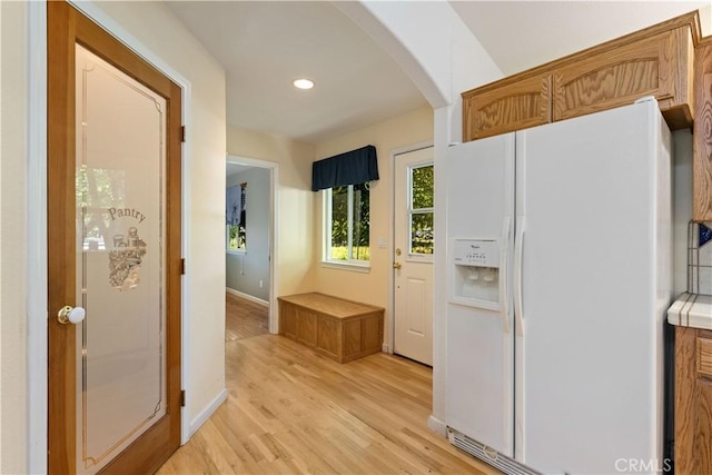 kitchen featuring white refrigerator with ice dispenser and light hardwood / wood-style floors