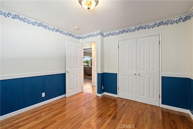 unfurnished bedroom with hardwood / wood-style flooring and a closet