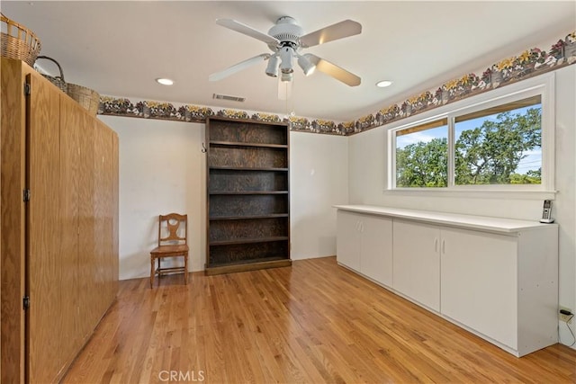 empty room with ceiling fan and light hardwood / wood-style flooring