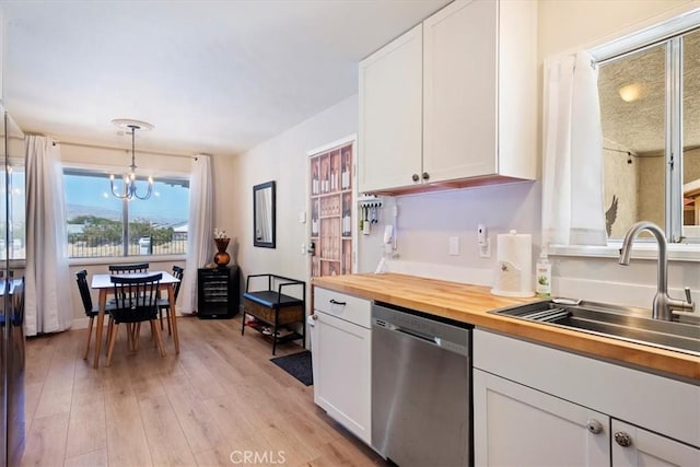 kitchen with white cabinets, an inviting chandelier, stainless steel dishwasher, and hanging light fixtures