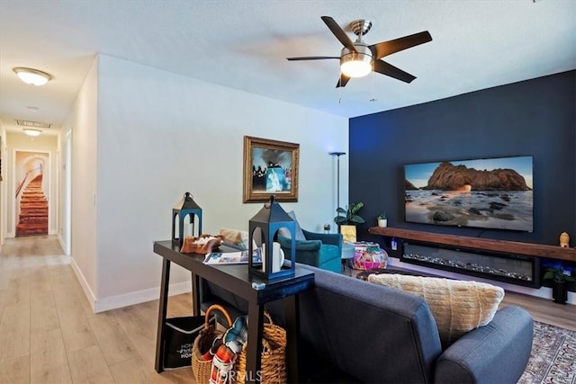 living room with ceiling fan and light wood-type flooring