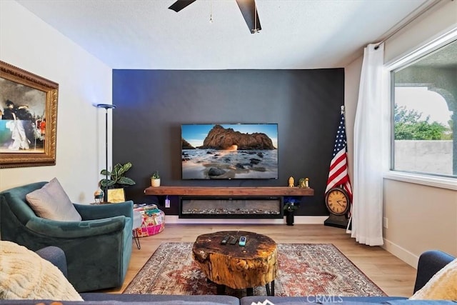 home theater room featuring light wood-type flooring and ceiling fan