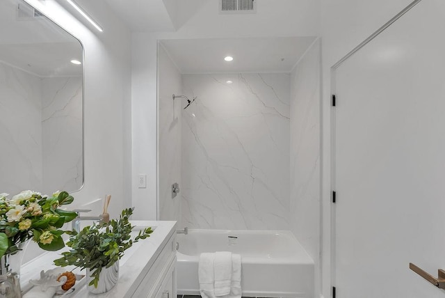 bathroom featuring tiled shower / bath and vanity