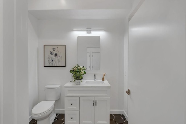 bathroom featuring toilet, vanity, and tile patterned flooring