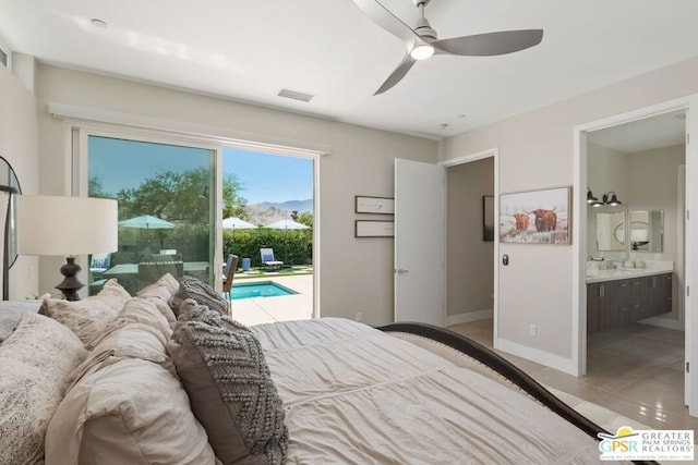 tiled bedroom with a mountain view, connected bathroom, access to outside, and ceiling fan