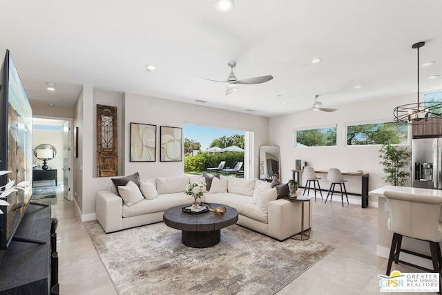 living room with ceiling fan with notable chandelier