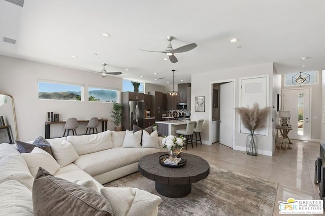 living room with ceiling fan and light tile patterned flooring