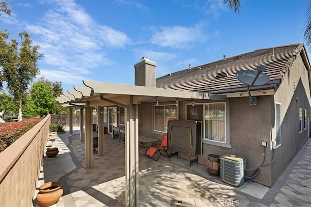 back of property with a pergola, a patio, and central air condition unit