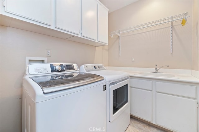 laundry room with cabinets, sink, and washer and dryer