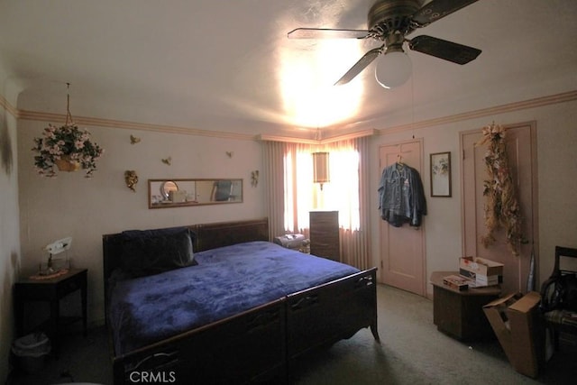 carpeted bedroom with ornamental molding and ceiling fan