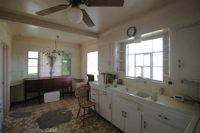 kitchen with white cabinetry, sink, pendant lighting, and ceiling fan