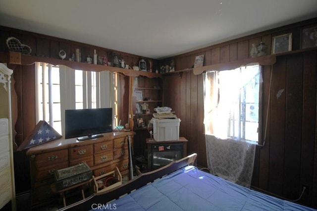 bedroom featuring wooden walls