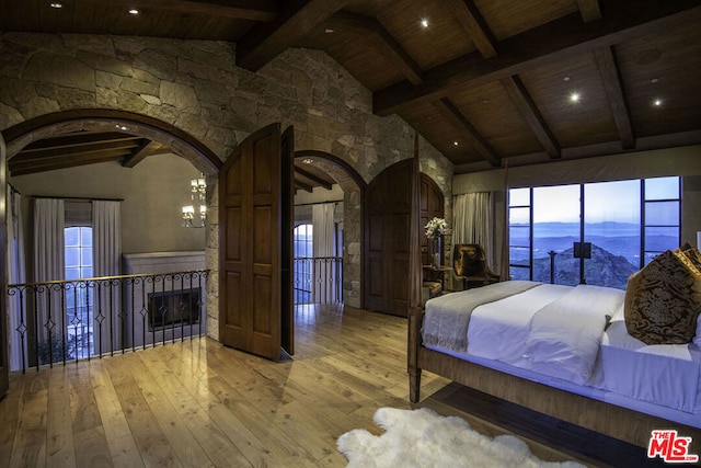 bedroom with beamed ceiling, wood-type flooring, and a mountain view