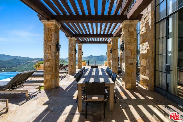 view of terrace featuring a pergola and a mountain view