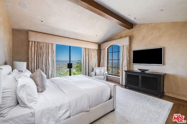 bedroom with access to outside, lofted ceiling with beams, multiple windows, and hardwood / wood-style floors