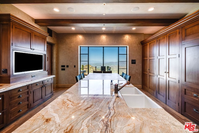 kitchen featuring beam ceiling, sink, and wood-type flooring