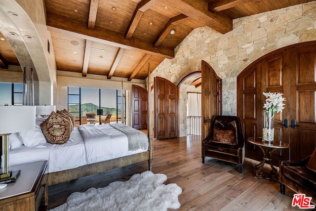 bedroom with hardwood / wood-style floors, lofted ceiling with beams, and wood ceiling