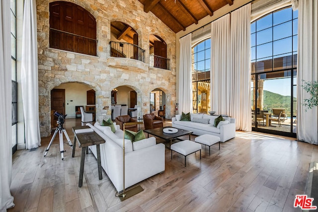 living room featuring beamed ceiling, high vaulted ceiling, hardwood / wood-style flooring, and wood ceiling