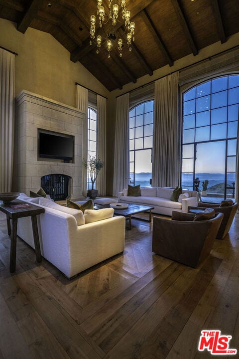 living room with an inviting chandelier, hardwood / wood-style flooring, wooden ceiling, beam ceiling, and high vaulted ceiling