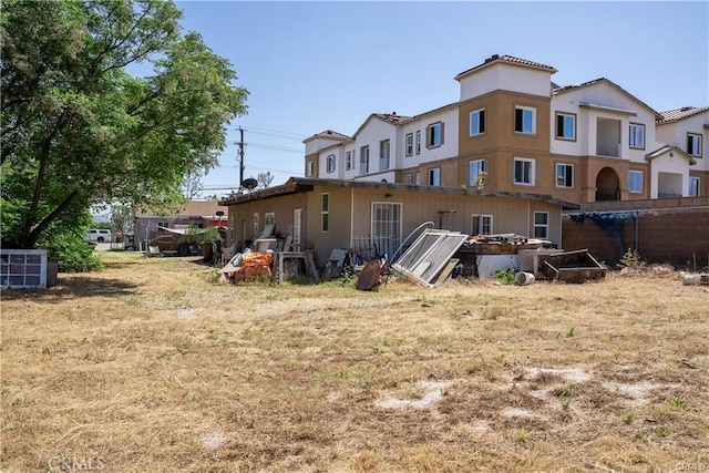 back of property featuring a deck and a yard