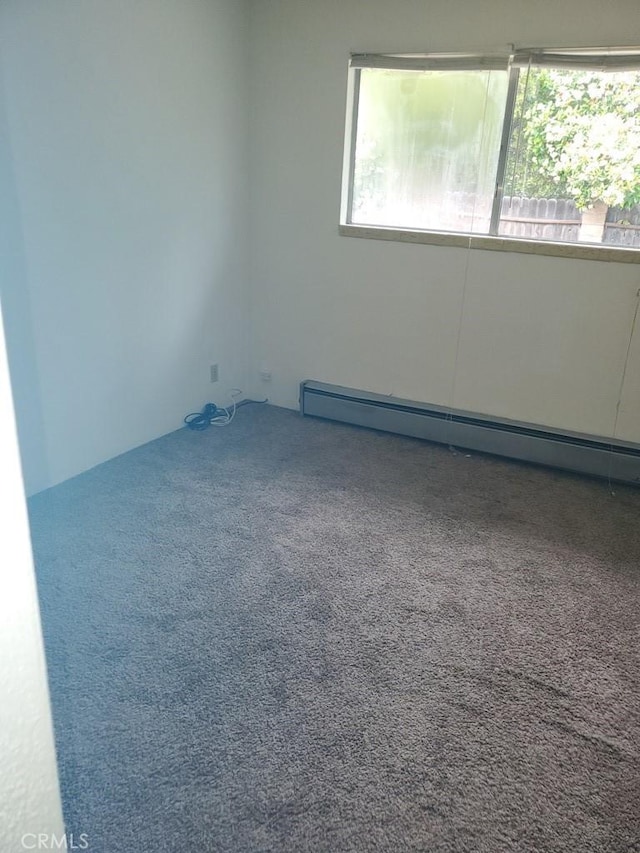 empty room with carpet floors and a baseboard radiator