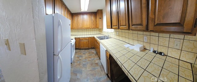 kitchen featuring white appliances, tile countertops, and sink