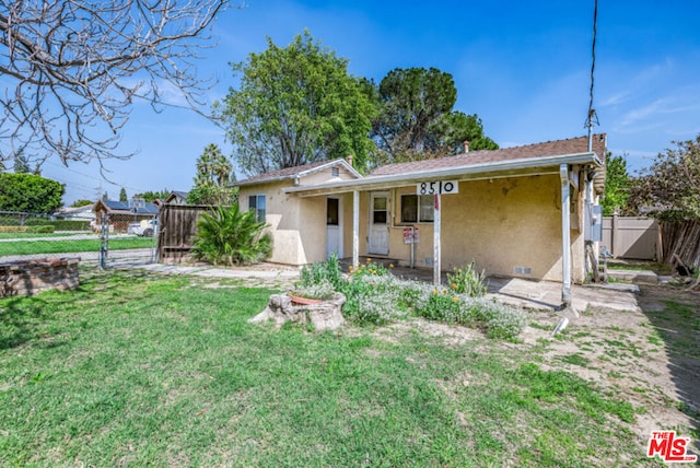 rear view of property featuring a lawn