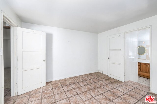 unfurnished room featuring light tile floors