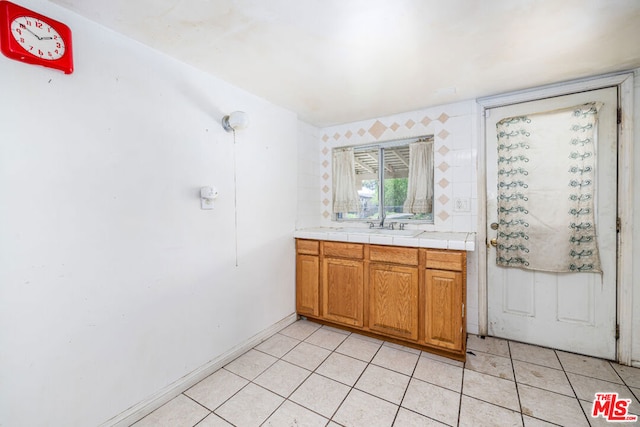 bar with sink, light tile floors, and tile counters