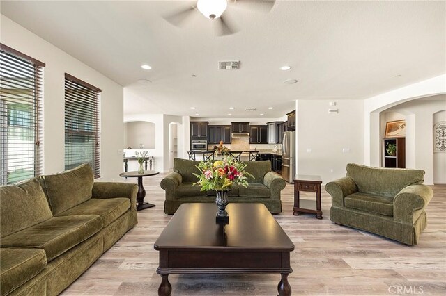 living room with ceiling fan and light hardwood / wood-style floors