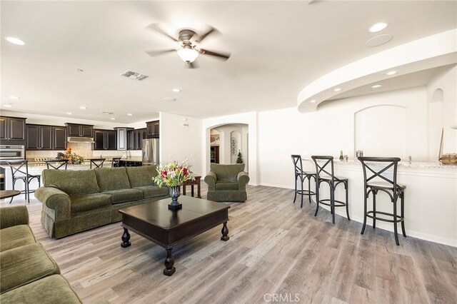 living room with ceiling fan and light wood-type flooring