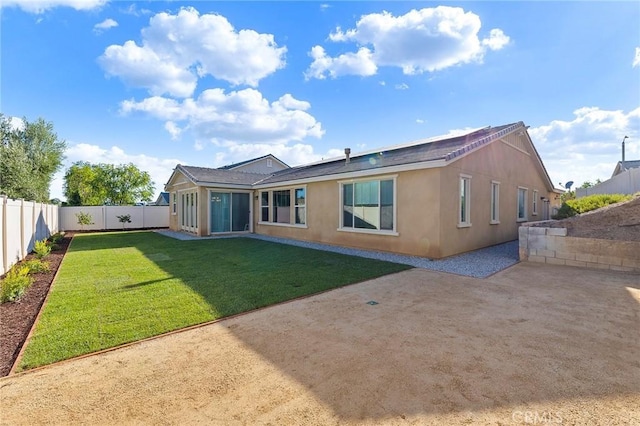 rear view of house featuring a lawn and a patio area