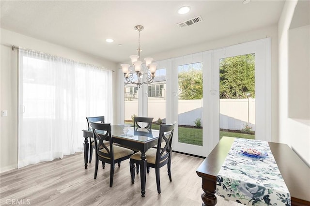 dining room featuring light hardwood / wood-style floors and a notable chandelier