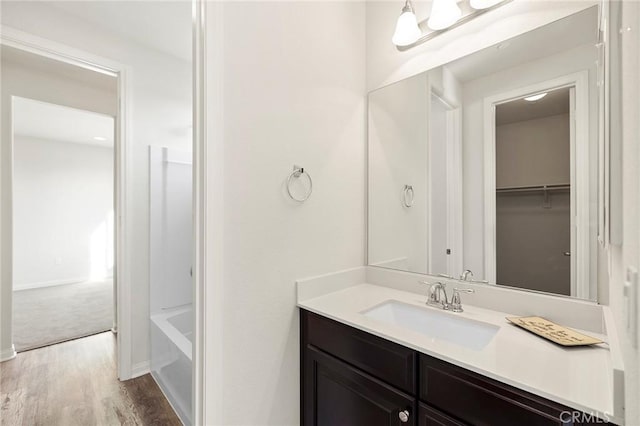 bathroom featuring vanity, a washtub, and hardwood / wood-style flooring