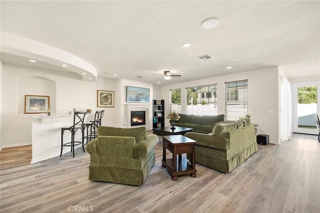 living room featuring ceiling fan and light hardwood / wood-style floors