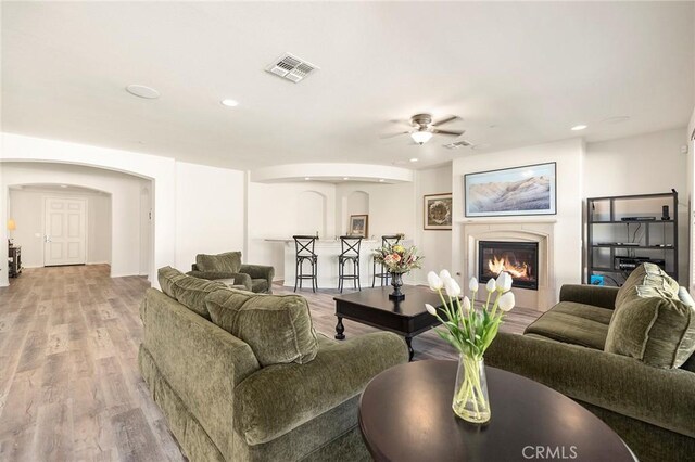 living room featuring ceiling fan and light hardwood / wood-style floors