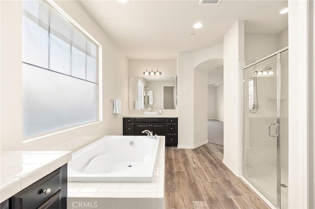 bathroom with vanity, independent shower and bath, and hardwood / wood-style floors