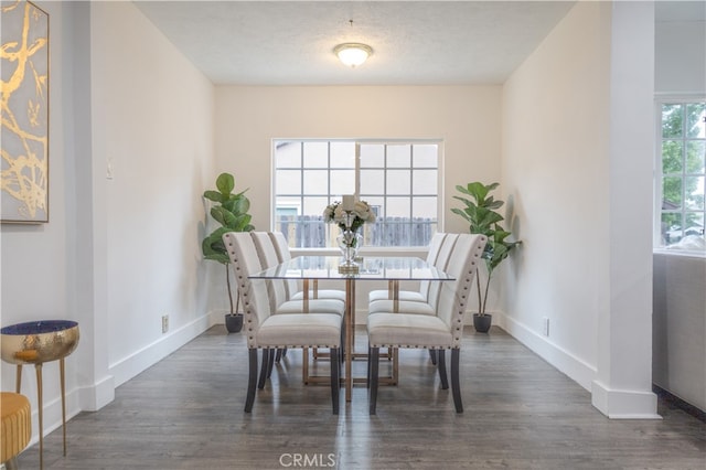 dining area featuring dark hardwood / wood-style flooring and a textured ceiling